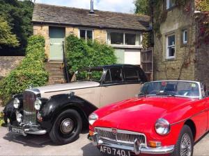 a red and white car parked in front of a house at The Bailey Shepherd's Hut and Holiday Cottage in Skipton