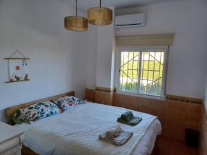 een slaapkamer met een bed met handdoeken en een raam bij Beautiful Villa with huge private pool and vineyard view in Valencia