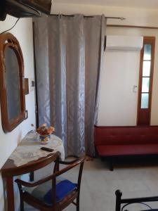 Habitación con mesa, silla y ventana en B&b La Palma, en Sferracavallo