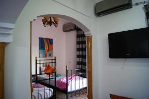 a room with two bunk beds and a flat screen tv at Villa Ayche in Marrakech