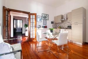 a kitchen with a glass table and white chairs at Butterfly Apartment in Rapallo +21 photos