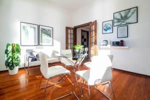 ein Esszimmer mit einem Glastisch und weißen Stühlen in der Unterkunft Butterfly Apartment in Rapallo
