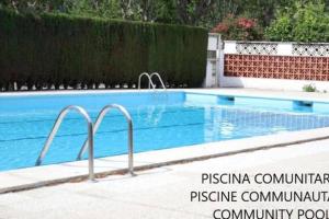 una piscina en un patio junto a una valla en TRA9-CASA con BARBACOA, PISCINA comunitaria en verano, 5 min en coche del MAR y el CENTRO, en Empuriabrava