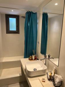 a bathroom with a sink and a tub and a mirror at Rodi Apartments in Parikia