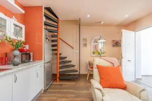 sala de estar con sofá y paredes de color naranja en TRA9-CASA con BARBACOA, PISCINA comunitaria en verano, 5 min en coche del MAR y el CENTRO, en Empuriabrava