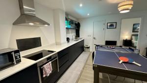 a kitchen with a ping pong table in the middle at Lux Livin' Apartments - Luxury 2 Bed Apartment with Sky Garden in Manchester