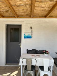 a white table with two chairs and a door at Rodi Apartments in Parikia