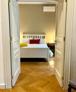 una camera con un letto bianco e un cuscino rosso di NAPOLIFOREVER Chiaia APARTMENT a Napoli