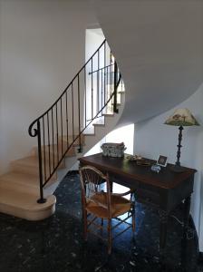 a room with a desk and a staircase with a lamp at Le clos du prieuré in Montjean-sur-Loire