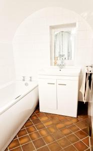 Baño blanco con bañera y lavamanos en THE OLD WASH KITCHEN - Charming Character Cottage in Holmfirth, Yorkshire en Holmfirth