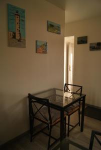 una mesa de cristal y 2 sillas en una habitación en La longère de Suzanne, en Arrest
