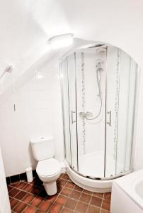 La salle de bains blanche est pourvue d'une douche et de toilettes. dans l'établissement THE OLD WASH KITCHEN - Charming Character Cottage in Holmfirth, Yorkshire, à Purmerend