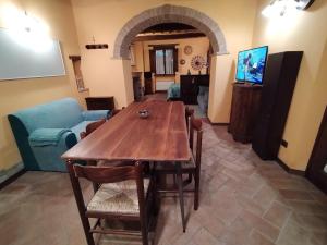 un soggiorno con tavolo e sedie in legno di Trame di luce a Pietrafitta