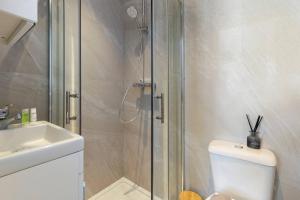 a bathroom with a shower and a toilet and a sink at Modern Cosy Haven For Travelers in Hanwell