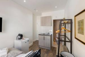 a room with a kitchen and a ladder in it at Modern Cosy Haven For Travelers in Hanwell