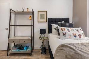 a bedroom with a bed and a night stand next to it at Modern Cosy Haven For Travelers in Hanwell