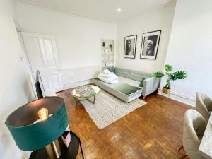a living room with a couch and a table at Captivating 2-Bed Flat in Maida Vale near Abbey Road in London
