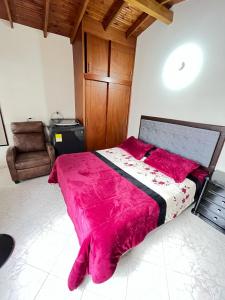 a bedroom with a large bed with a pink blanket at aparta estudio en envigado in Envigado