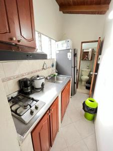 a kitchen with a stove and a sink and a refrigerator at aparta estudio en envigado in Envigado