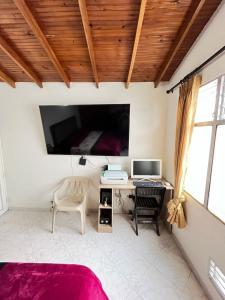 a bedroom with a desk and a computer on a wall at aparta estudio en envigado in Envigado