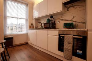 ウェイマスにあるSmart Tvself Check-in2mins To Weymouth Beachのキッチン(白いキャビネット、コンロ付) +20枚の写真