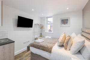 a bedroom with a bed and a flat screen tv at Modern Studio Retreat Near Shop's! in Ealing