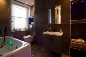 ウェイマスにあるSmart Tvself Check-in2mins To Weymouth Beachの浴槽、洗面台、トイレを備えたバスルーム