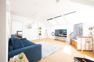 un soggiorno con divano blu e TV di Ko-Living - Captain's Suite - Altstadt - mit Küche, Smart TV & Balkon - 6P a Halle an der Saale