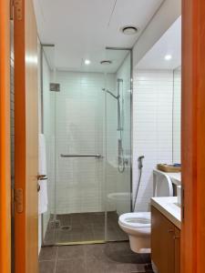 a bathroom with a glass shower and a toilet at Luxury private sea view room in Abu Dhabi