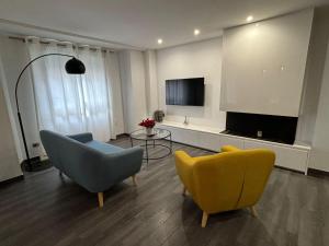 - un salon avec deux chaises et une télévision dans l'établissement Increíble piso céntrico, à Gandía