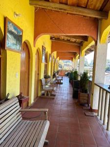 a building with benches and tables on a patio at CasaDolomiti Coban Guest House in Cobán