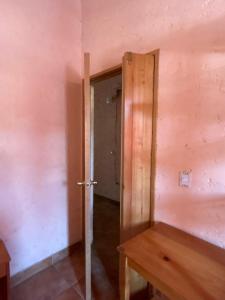 Habitación vacía con puerta y mesa de madera en CasaDolomiti Coban Guest House en Cobán