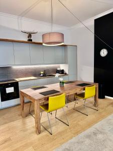 eine Küche mit einem Holztisch und gelben Stühlen in der Unterkunft Vieil Antibes Apartment with AC 320m from Beach in Antibes