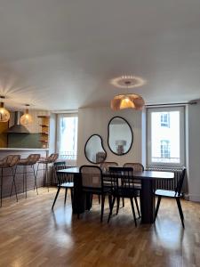 a dining room with a table and chairs and mirrors at Grand Appartement ultra moderne Plein Centre, plage à pieds, avec parking in Concarneau
