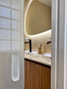 La salle de bains est pourvue d'un lavabo et d'un miroir. dans l'établissement Grand Appartement ultra moderne Plein Centre, plage à pieds, avec parking, à Concarneau
