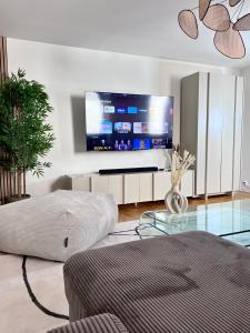 - un salon avec une grande télévision à écran plat dans l'établissement Grand Appartement ultra moderne Plein Centre, plage à pieds, avec parking, à Concarneau