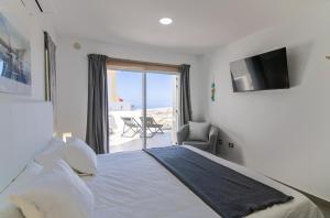 una camera con letto, TV e balcone di Mirador Balcon del Atlantico y piscina privada ad Adeje