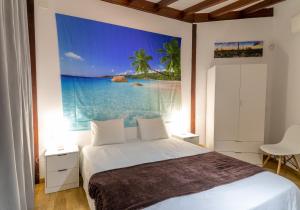 una camera da letto con un letto e un dipinto sul muro di Mirador Balcon del Atlantico y piscina privada ad Adeje