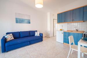 a living room with a blue couch and a kitchen at 1-bedroom 500m away from the beach in Kallithea Halkidikis