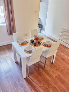 a white dining room table with white chairs and plates at Kenrick Street Affordable Convenient 2 Bedroom House Central Location Sleeps 6 NG4 Postcode in Nottingham