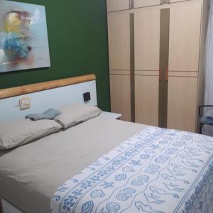 a bedroom with a bed and a green wall at Apart Quartier Latin in Vitória