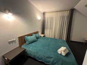 - une chambre avec un lit vert et des serviettes dans l'établissement TURQUOISE HOUSE, à Colibiţa