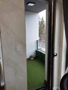 Otwarte drzwi na balkon z zieloną trawą w obiekcie Апартамент за гости Боляри 2 w mieście Welingrad
