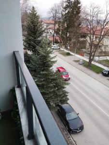 samochód zaparkowany na ulicy z choinką świąteczną na balkonie w obiekcie Апартамент за гости Боляри 2 w mieście Welingrad