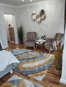 salon z 2 krzesłami i dywanem w obiekcie Апартамент за гости Боляри 2 w mieście Welingrad