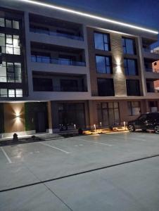 parking przed dużym budynkiem w obiekcie Апартамент за гости Боляри 2 w mieście Welingrad