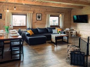 a living room with a couch and a table at Bieszczadzkie Chatki - Willa Stasia in Ustrzyki Dolne