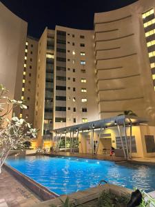 a swimming pool in front of a building at night at Luxury private sea view room in Abu Dhabi