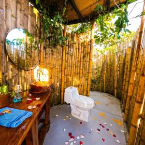 een badkamer met een toilet in een bamboe muur bij Mirador del Magdalena Hotel y Glamping in Isnos
