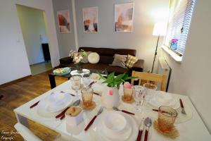 una sala de estar con una mesa con platos. en Apartament Działkowa przy Parku, en Chorzów